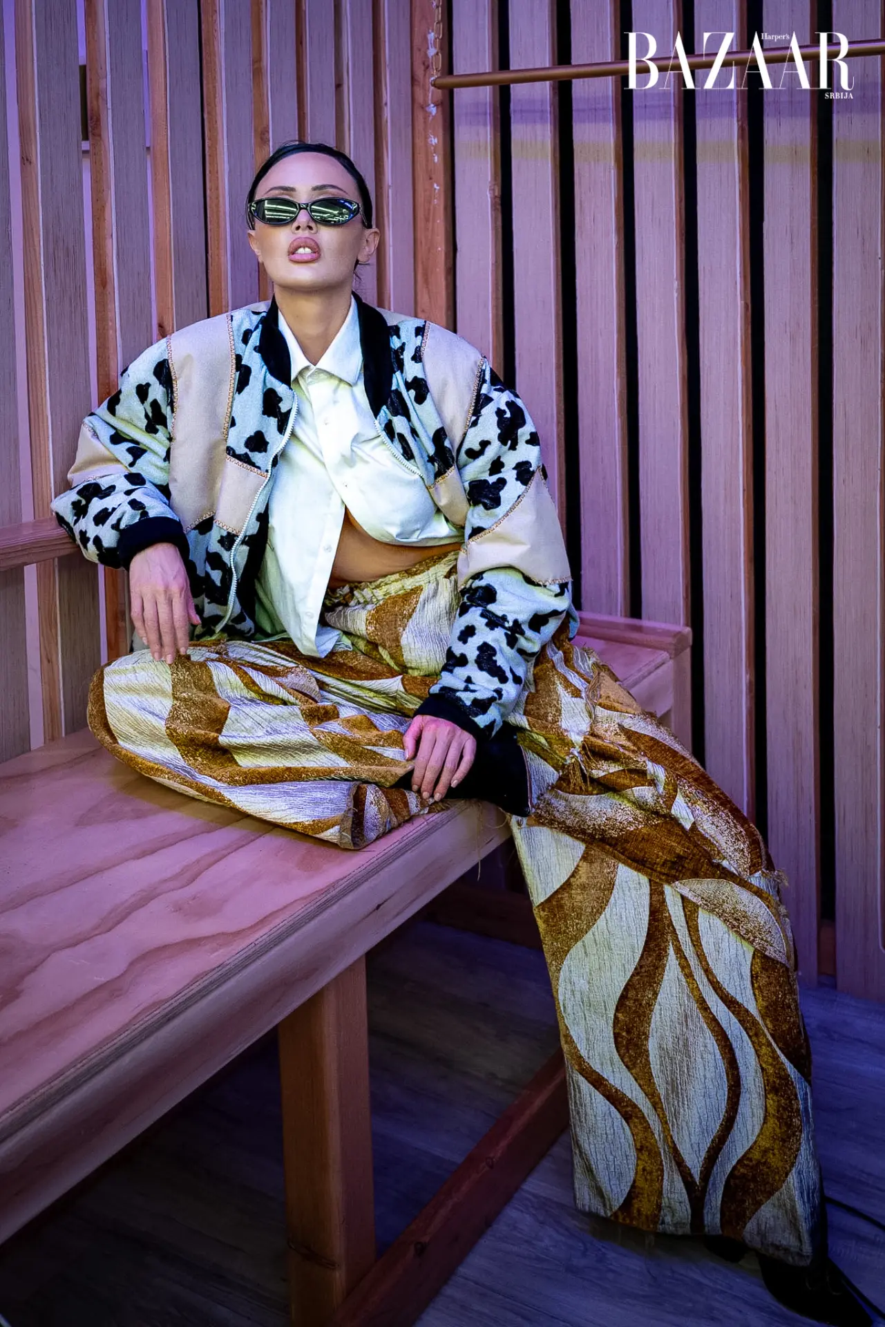 Model wearing a patterned jacket and gold trousers in Harper’s BAZAAR Serbia.